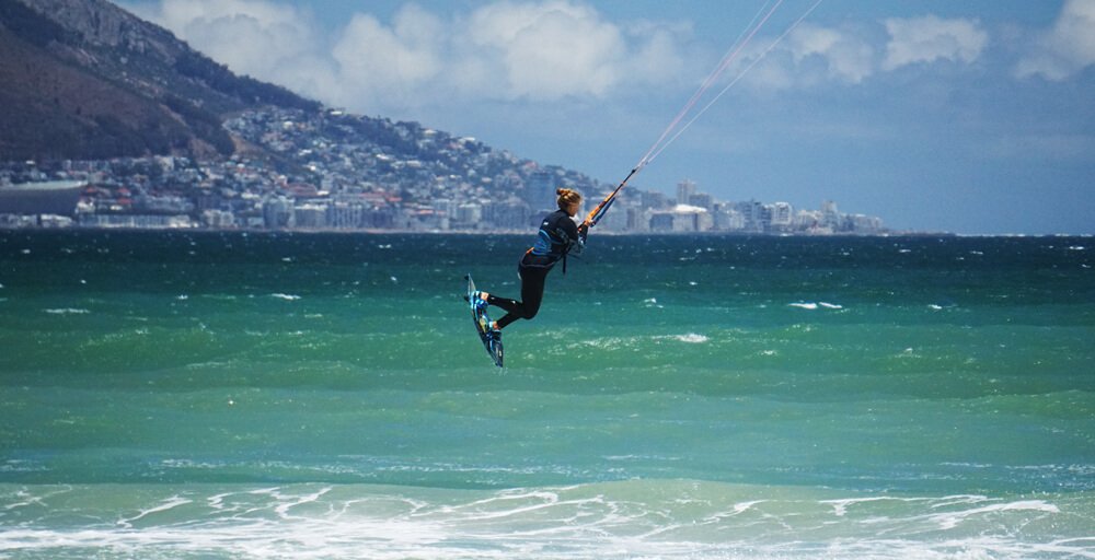 Kitesurf girl jumping at Kite Beach in Cape Town in front of Table Mountain